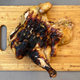 Aerial view of spatchcocked grilled chicken on a wooden cutting board